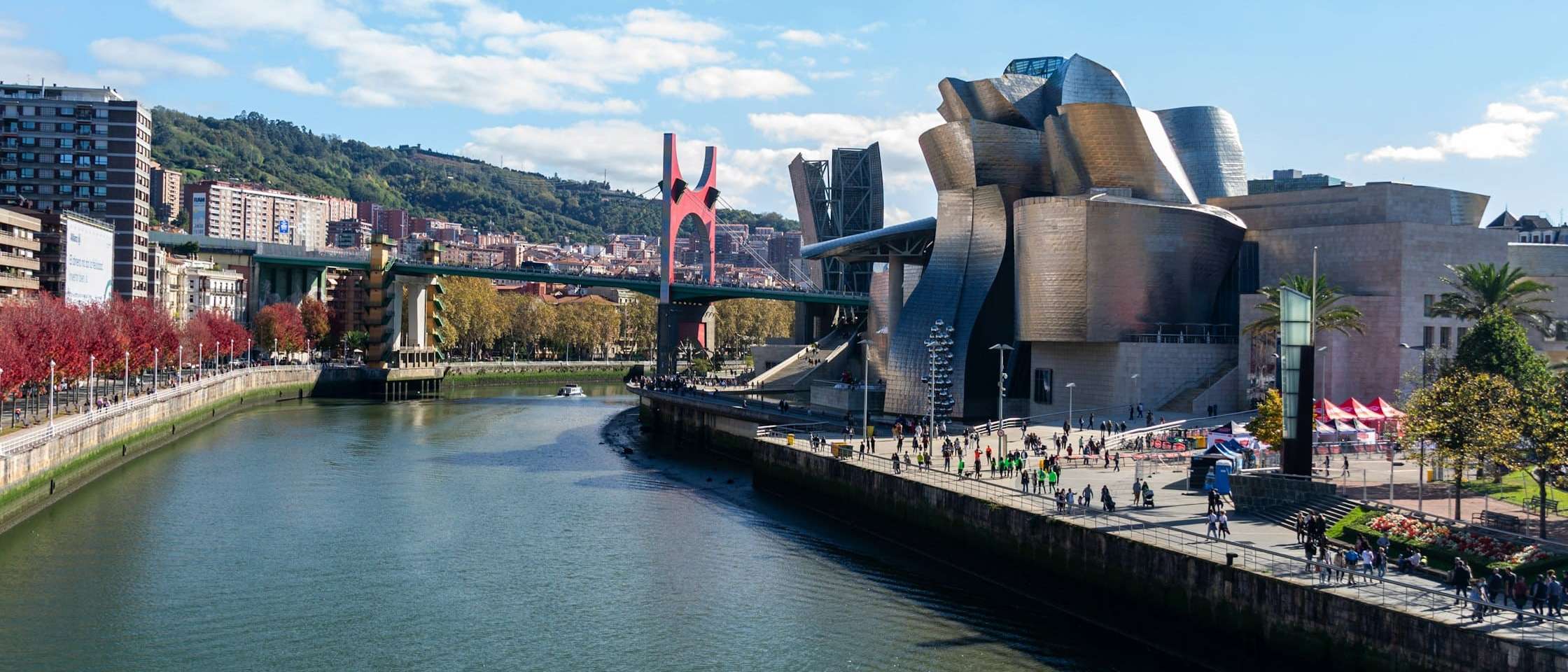 Paseo de Abandoibarra en Bilbao con gente paseando, el Guggenheim y el puente de La Salve